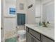 Bathroom with walk in shower, modern vanity with white marble countertop, and tiled floor at 15498 Seafoam Cir, Port Charlotte, FL 33981