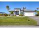 Beautiful contemporary home with a well-manicured lawn, lush landscaping, and a two-car garage at 15498 Seafoam Cir, Port Charlotte, FL 33981