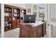 This home office includes built-in shelving, a sleek desk, and bright light at 15498 Seafoam Cir, Port Charlotte, FL 33981