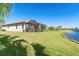 Beautiful backyard featuring a screened lanai, spacious lawn, and tranquil pond views at 156 Nolen Dr, Venice, FL 34292