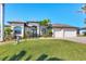 Charming home with an immaculate lawn, artful landscaping, and a two-car garage, reflecting pride of ownership at 15690 Viscount Cir, Port Charlotte, FL 33981