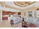 Open-concept living room showcasing tray ceilings and furniture, flowing seamlessly into the kitchen at 15690 Viscount Cir, Port Charlotte, FL 33981