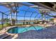 Screened-in pool area with a tranquil waterfront view, perfect for outdoor enjoyment and relaxation at 15690 Viscount Cir, Port Charlotte, FL 33981