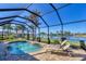 Enclosed pool features brick paving, sun loungers and a view of the lake at 15690 Viscount Cir, Port Charlotte, FL 33981