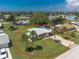 An aerial view showcasing a charming single-Gathering home with a well-manicured lawn and two palm trees in the front yard at 1680 Meadow Lark Ln, Englewood, FL 34224