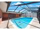 In-ground pool in screened enclosure features turtle mosaic and ceiling fans at 1694 Harbor W Cir, Largo, FL 33770