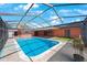 In-ground pool in screened enclosure features turtle mosaic and outdoor kitchen at 1694 Harbor W Cir, Largo, FL 33770