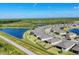 Aerial view of a planned community with homes surrounding a lake at 1824 Saddlewood Cir, Port Charlotte, FL 33953