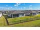 Aerial view of home and backyard featuring a screen patio, fenced yard, and well-maintained lawn at 1824 Saddlewood Cir, Port Charlotte, FL 33953