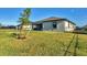 Home's beautiful backyard with healthy green grass, small tree, and black fencing at 1824 Saddlewood Cir, Port Charlotte, FL 33953