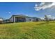 A covered patio with outdoor seating overlooks a spacious, fenced backyard with lush grass at 1824 Saddlewood Cir, Port Charlotte, FL 33953