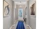 Inviting hallway with modern light fixture, art, and a blue geometric runner rug at 1824 Saddlewood Cir, Port Charlotte, FL 33953