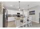 Modern kitchen featuring white cabinets, stainless steel appliances, tile backsplash, and granite island with barstool seating at 1824 Saddlewood Cir, Port Charlotte, FL 33953