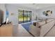 Bright living room featuring neutral tones, a large sectional sofa, and sliding glass doors to the backyard at 1824 Saddlewood Cir, Port Charlotte, FL 33953