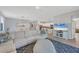 Open-concept living room with large sectional sofa, adjacent dining area and kitchen with stainless steel appliances at 1824 Saddlewood Cir, Port Charlotte, FL 33953