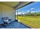 Inviting covered patio with comfortable rocking chair seating and backyard view at 1824 Saddlewood Cir, Port Charlotte, FL 33953