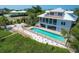 An aerial view of the backyard featuring a pool, patio, fire pit and coastal home at 19 Grouper Hole Dr, Boca Grande, FL 33921