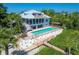 Beautiful backyard featuring a sparkling pool, a wooden walkway, and lush landscaping at 19 Grouper Hole Dr, Boca Grande, FL 33921