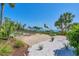 Backyard view with a brick paver patio, fire pit, and distant waterway views at 19 Grouper Hole Dr, Boca Grande, FL 33921