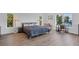 Relaxing bedroom with wood floors, seating area, and natural light from the surrounding windows at 19 Grouper Hole Dr, Boca Grande, FL 33921
