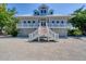 Inviting home exterior with landscaped front yard, covered porch, and dual garages at 19 Grouper Hole Dr, Boca Grande, FL 33921