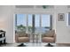 Cozy sitting area with water views, neutral armchairs and view to the balcony at 19 Grouper Hole Dr, Boca Grande, FL 33921