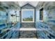 Shower boasting unique blue tiled walls, a shower bench, and a large window that streams in natural light at 19 Grouper Hole Dr, Boca Grande, FL 33921
