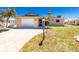 Inviting home with a brick driveway, a manicured lawn, and mature landscaping at 1957 Arkansas Ave, Englewood, FL 34224