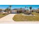 Inviting home features a manicured lawn, brick driveway, and attached garage at 1957 Arkansas Ave, Englewood, FL 34224