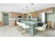 Open kitchen with pendant lights, a center island and stainless steel appliances at 1957 Arkansas Ave, Englewood, FL 34224