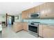 Well-lit kitchen equipped with stainless steel appliances and updated cabinets at 1957 Arkansas Ave, Englewood, FL 34224