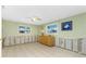 Spacious living room with tile flooring, ceiling fan, and natural light from windows at 1957 Arkansas Ave, Englewood, FL 34224