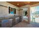 Covered outdoor kitchen and bar offers access to the bedroom and pool; perfect for indoor/outdoor living at 1957 Arkansas Ave, Englewood, FL 34224