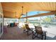 Expansive covered patio featuring a canal view, tile flooring, wood ceiling, and comfortable seating areas at 1957 Arkansas Ave, Englewood, FL 34224