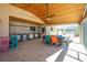 Outdoor kitchen with bar, dining set, tongue and groove ceiling on the covered patio for seamless entertaining at 1957 Arkansas Ave, Englewood, FL 34224