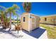 Backyard shed offering extra storage space with adjacent greenery and palm trees at 1957 Arkansas Ave, Englewood, FL 34224