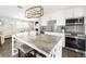 Well-lit kitchen with a marble island, white cabinetry, stainless steel appliances, and open to the living area at 2105 Arkansas Ave, Englewood, FL 34224