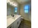 Bathroom featuring a large mirror, modern vanity with dark hardware, and wood-look flooring at 220 Jennifer Dr, Rotonda West, FL 33947