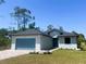 Charming one-story home with blue garage door and landscaped front yard at 220 Jennifer Dr, Rotonda West, FL 33947