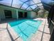Beautiful backyard pool with a screened enclosure and tiled patio area at 220 Jennifer Dr, Rotonda West, FL 33947