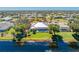 Aerial view of the home showing the pool, screened lanai, lush landscaping, and waterfront location at 228 White Marsh Ln, Rotonda West, FL 33947