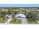Aerial view of the home showcasing the well-manicured lawn, waterfront views and the three-car garage at 228 White Marsh Ln, Rotonda West, FL 33947