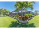 Lush landscaping and mature palm trees surround this well-maintained backyard and screened-in pool at 228 White Marsh Ln, Rotonda West, FL 33947