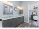 Bathroom featuring double vanity sinks with gray cabinets and marble countertops at 228 White Marsh Ln, Rotonda West, FL 33947