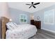 Comfortable bedroom with two windows, modern ceiling fan, and wood-look vinyl floors at 228 White Marsh Ln, Rotonda West, FL 33947