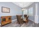 Dining room boasts stylish hardwood flooring, a modern chandelier, and bright shuttered windows at 228 White Marsh Ln, Rotonda West, FL 33947