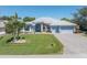 Charming single-story home with lush landscaping, a paver driveway, and a three-car garage at 228 White Marsh Ln, Rotonda West, FL 33947