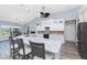 Bright kitchen with white cabinets, stone countertops, gray backsplash, and stainless appliances at 228 White Marsh Ln, Rotonda West, FL 33947