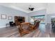 Inviting living room with wood floors, rattan furniture, and a sliding glass door leading to a screened-in pool area at 228 White Marsh Ln, Rotonda West, FL 33947