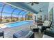 Relaxing screened-in pool area with outdoor seating and a beautiful blue pool at 228 White Marsh Ln, Rotonda West, FL 33947